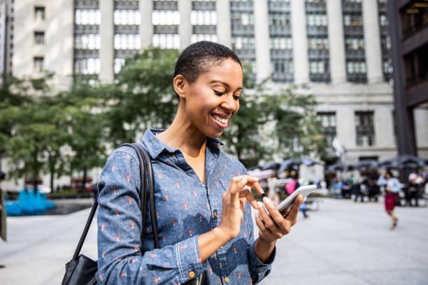 istock Woman texting on mobile phone while is walking in downtown Chicago 955120306