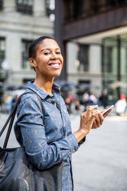 istock Woman texting on mobile phone while is walking in downtown Chicago 955120332