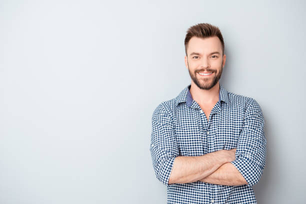 istock Happy smiling cheerful guy with crossed hands on gray background 955123410