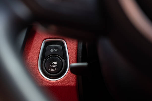 istock Close-up, isolated image of an engine Start Stop button seen on the dashboard of a german manufactured sports car, also showing its part red leather. 955123710