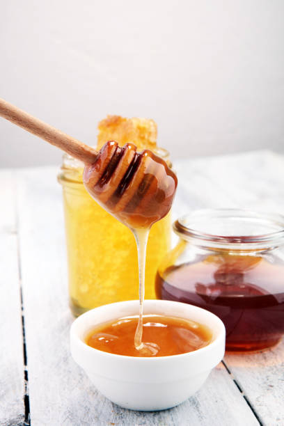 istock Pouring aromatic honey into jar, closeup 955123970