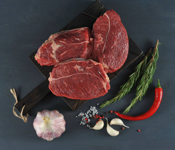 istock raw beef steaks on wooden Board 955124062