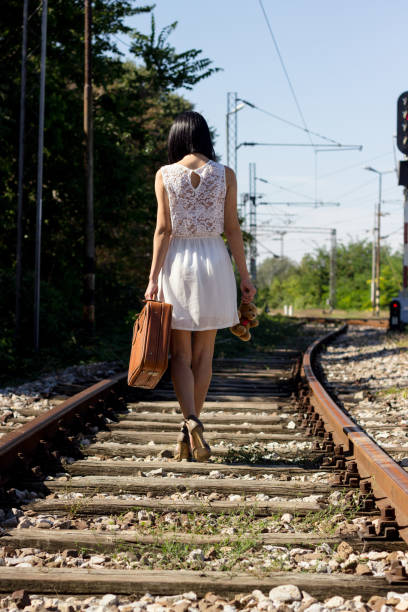 frau auf der bahn, zu fuß - leaving loneliness women railroad track stock-fotos und bilder