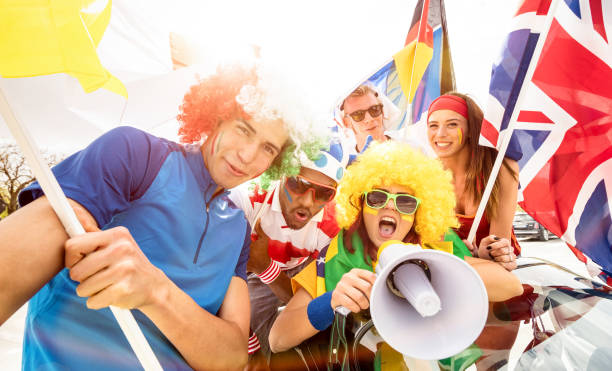 Football supporter fans friends taking selfie after soccer match hanging around together - Young people group with multicolored t-shirts and wigs having excited fun. Football supporter fans friends cheering after soccer cup match hanging around with car and flags - Young people group with multicolored t-shirts having excited fun international match stock pictures, royalty-free photos & images