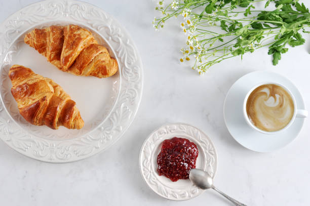 istock Breakfast with croissants, raspberry jam and cappuccino 955127396