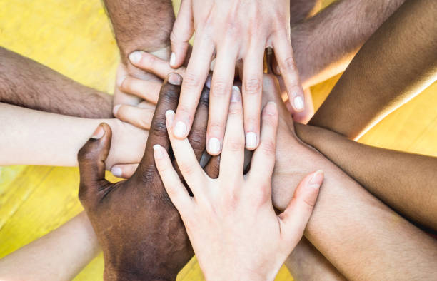 istock Top view of multiracial stacking hands - International friendship concept with multiethnic people representing peace and unity against racism - Multi racial love and integration between diversity 955132586