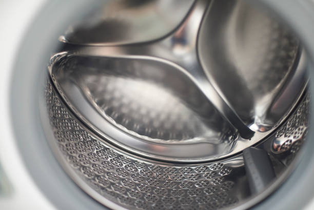 metal washing machine drum inside the washing machine. view of the metal drum without clothes. with drainage holes washing machine drum stock pictures, royalty-free photos & images
