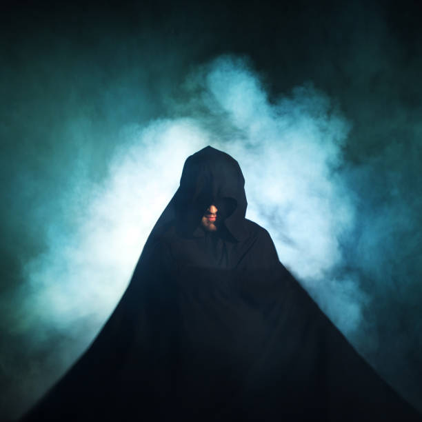 istock Gloomy image. Man in a black cloak. Demonic image. Magician illusionist 955135780
