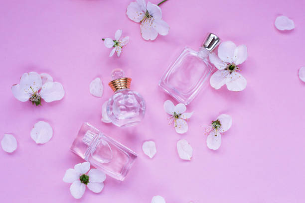 istock Three bottles of perfume with petals on pink background 955136716