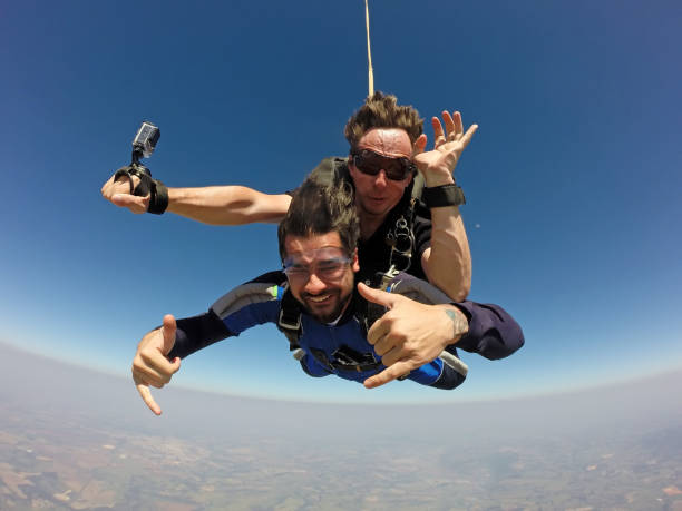 skydivers making a tandem jump - airplane sky extreme sports men imagens e fotografias de stock