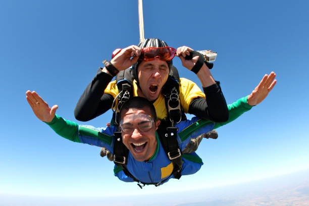 Skydiving tandem grimace A parachutist makes a face and the other shouts of happiness skydiving stock pictures, royalty-free photos & images