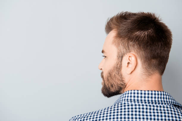 istock Back view of young bearded brunet man on gray background 955139946