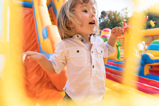 istock Little kid having fun in inflatable castle playground 955140370