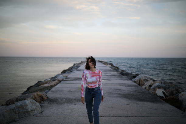 istock Girl on the pier during sun set 955145210