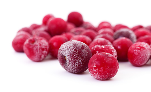 Group of frozen cherries on a white background.
