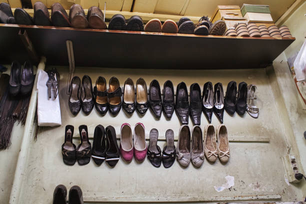 istock Craftsman repairing second hand shop shoes 955147406