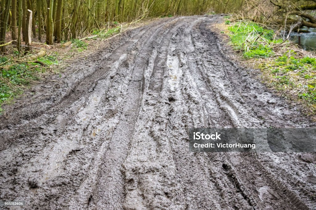Muddy trail with tire tracks next to River Cole in Whelford, England Extremely muddy trail with messy tire tracks next to River Cole in Whelford, England Fairford Stock Photo