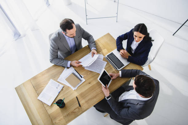 istock high angle view of businesspeople working with digital devices in office 955152912