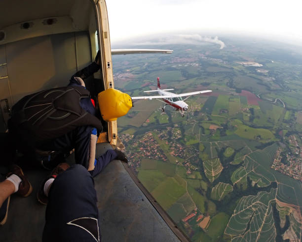 image des parachutistes à l’intérieur de l’avion d’un autre avion - airplane stunt yellow flying photos et images de collection