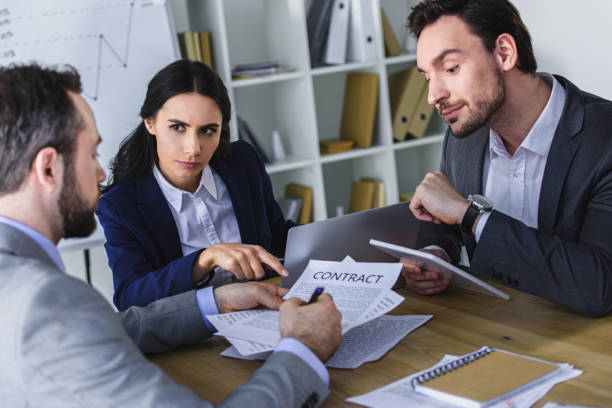 istock businesspeople discussing contract at table in office 955153096