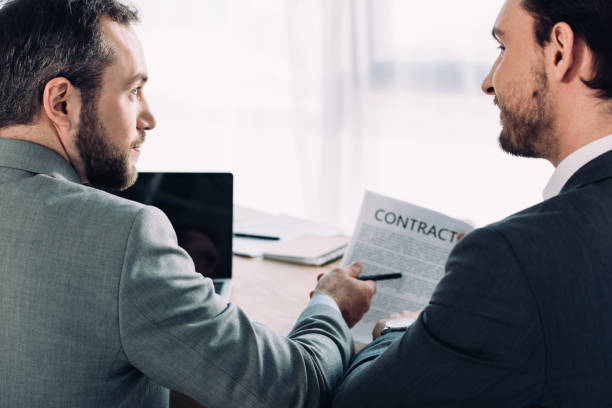 istock side view of handsome businessmen looking at each other in office 955157720