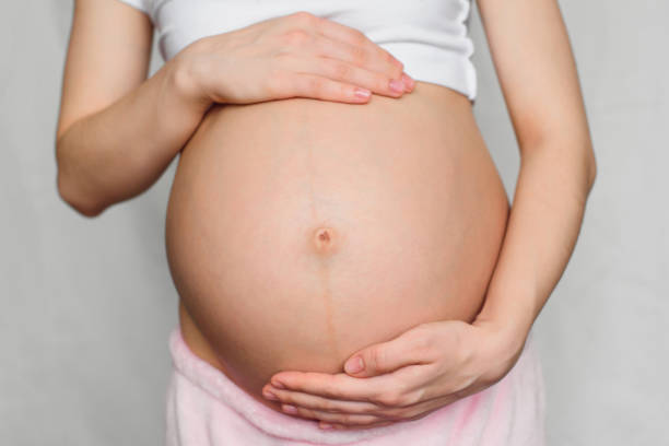 istock pregnant girl gently hugging her belly 955157896