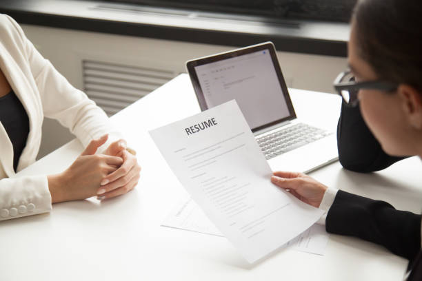 istock Company representatives reading applicant resume at hiring 955158604