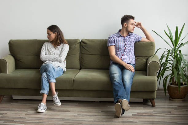 Couple sitting apart not talking because of quarrel Husband and wife sitting on different sides of couch not looking at each other and not talking, being in quarrel thinking about relationship problems, break up. Concept of family misunderstanding arguing couple divorce family stock pictures, royalty-free photos & images