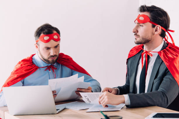 istock handsome super businessmen in masks and capes working with documents in office 955162024