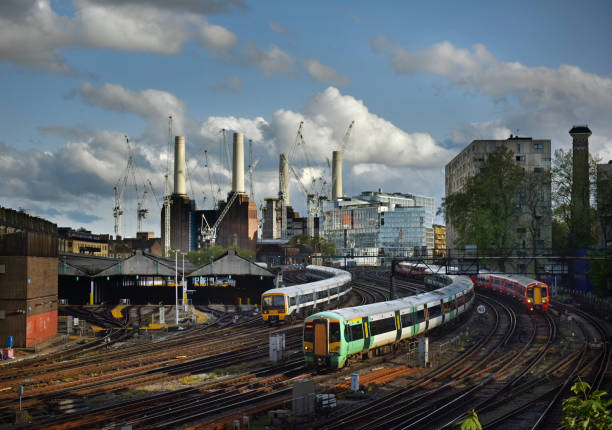 London trains Battersea Power Station the iconic decommissioned coal-fired power station located on the south bank of the River Thames in London. The Art Deco landmark  surrounded by cranes during redevelopment building work - seen from Victoria Railway Station approach and shunting yard with approaching trains wandsworth photos stock pictures, royalty-free photos & images