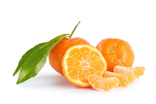 Whole and sliced mandarins on a white background Fresh orange mandarines, pieces, leaves and cross section against white background tangerine stock pictures, royalty-free photos & images