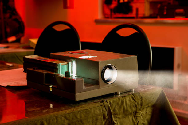 Old vintage slide projector working in dark room Old vintage slide projector working in dark room. slide projector photos stock pictures, royalty-free photos & images