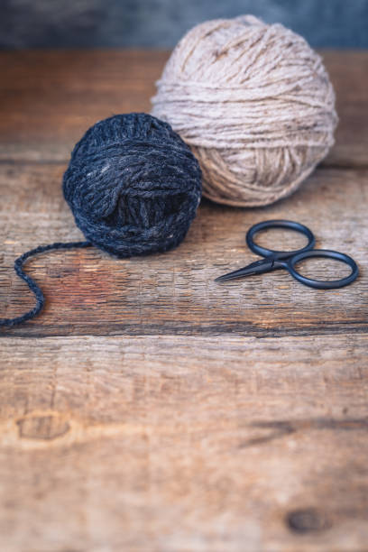 istock Beige and Grey yarn balls with scissors on a rustic wooden background 955169342