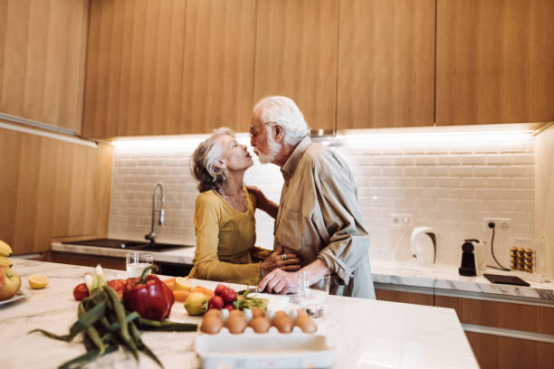 istock senior couple kissing on the kitchen 955169764