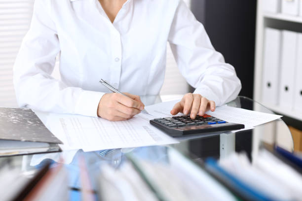 istock Female bookkeeper or financial inspector  making report, calculating or checking balance. Internal Revenue Service checking financial document. Audit concept in busines 955169900