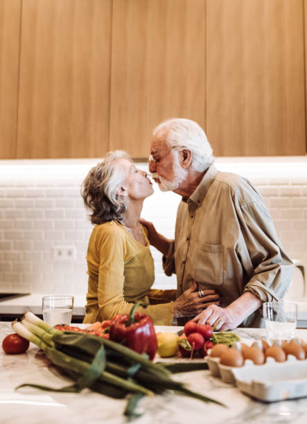 istock senior couple kissing on the kitchen 955170052