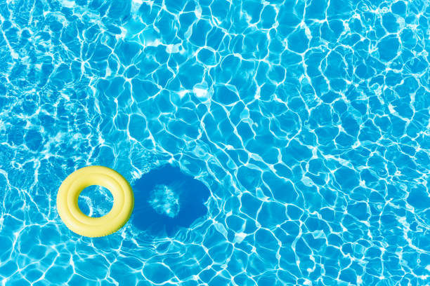 пустое резиновое кольцо, плавающее на синей поверхности воды - ring buoy стоковые фото и изображения