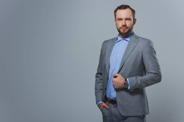 istock handsome businessman looking at camera isolated on grey 955175468