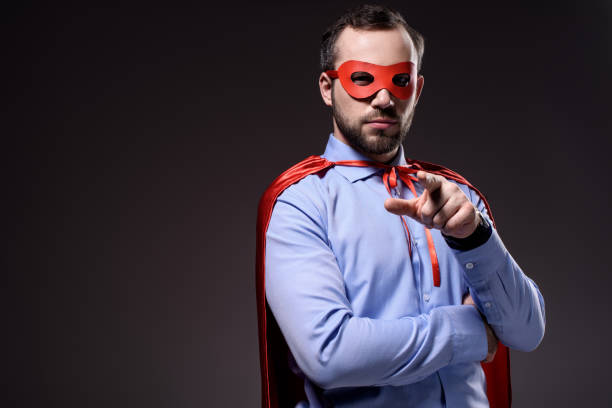 istock handsome super businessman in mask and cape pointing on camera isolated on black 955175634