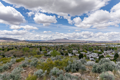 Springtime view with fluffy white clouds across the high desert of Reno, Nevada to Peavine Peak and the eastern Sierra Nevada mountains.