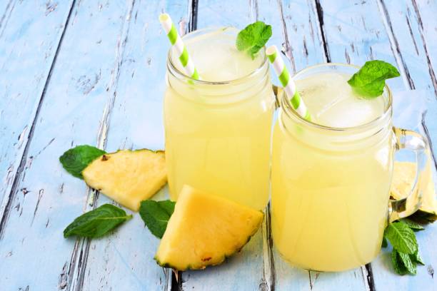 istock Pineapple juice in mason jars on rustic blue wood 955180528