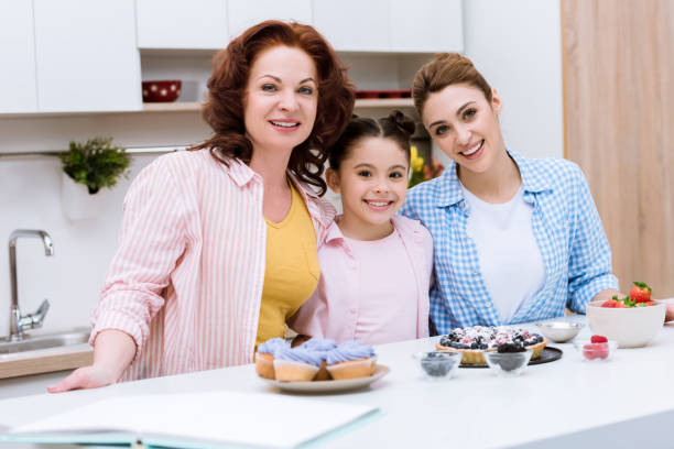 istock three generations of women with desserts at kitchen looking at camera 955180790