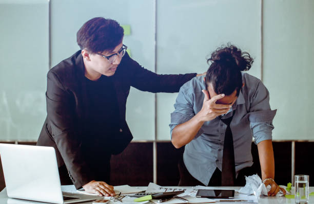 istock Office worker stressed and sad from erroneous work. There his friend comforts him. 955180954
