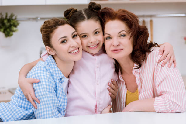 istock three generations of women embracing and looking at camera 955181046