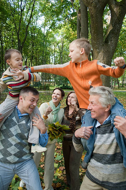 istock parents and children playing in autumn park 95518781