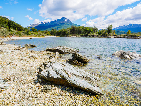 Stones on beach of Lapataia Bay with mountains in background, Terra del Fuego National Park near Ushuaia, Patagonia, Argentina