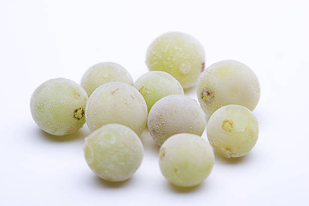 Frozen green grapes against white background Isolated green grapes with frost deposit frozen grapes stock pictures, royalty-free photos & images