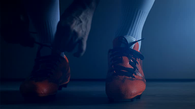 Soccer football player put on his shoes. Slow Motion.