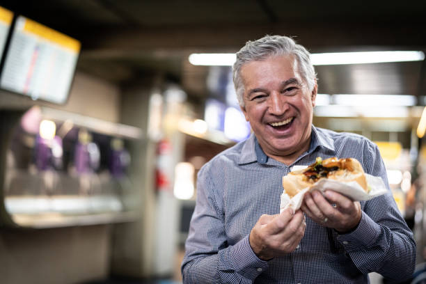 maduras viajero comiendo sandwich en aeropuerto - sandwich food lunch chicken fotografías e imágenes de stock