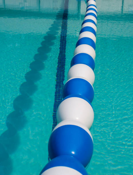 Pool divider floats. Pool divider floats dividing the deep end from the shallow end. Sparkling blue swimming pool water for travel vacation resort destination. Summertime activity of sport swimming in a pool. swimming pool lane ropes stock pictures, royalty-free photos & images
